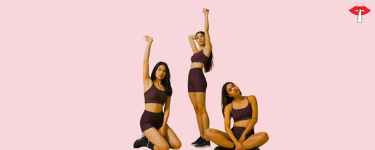 Group of women in Maroon Sports Bra and shorts posing confidently againsta. pink background showcasing activewear for fitness and sports 